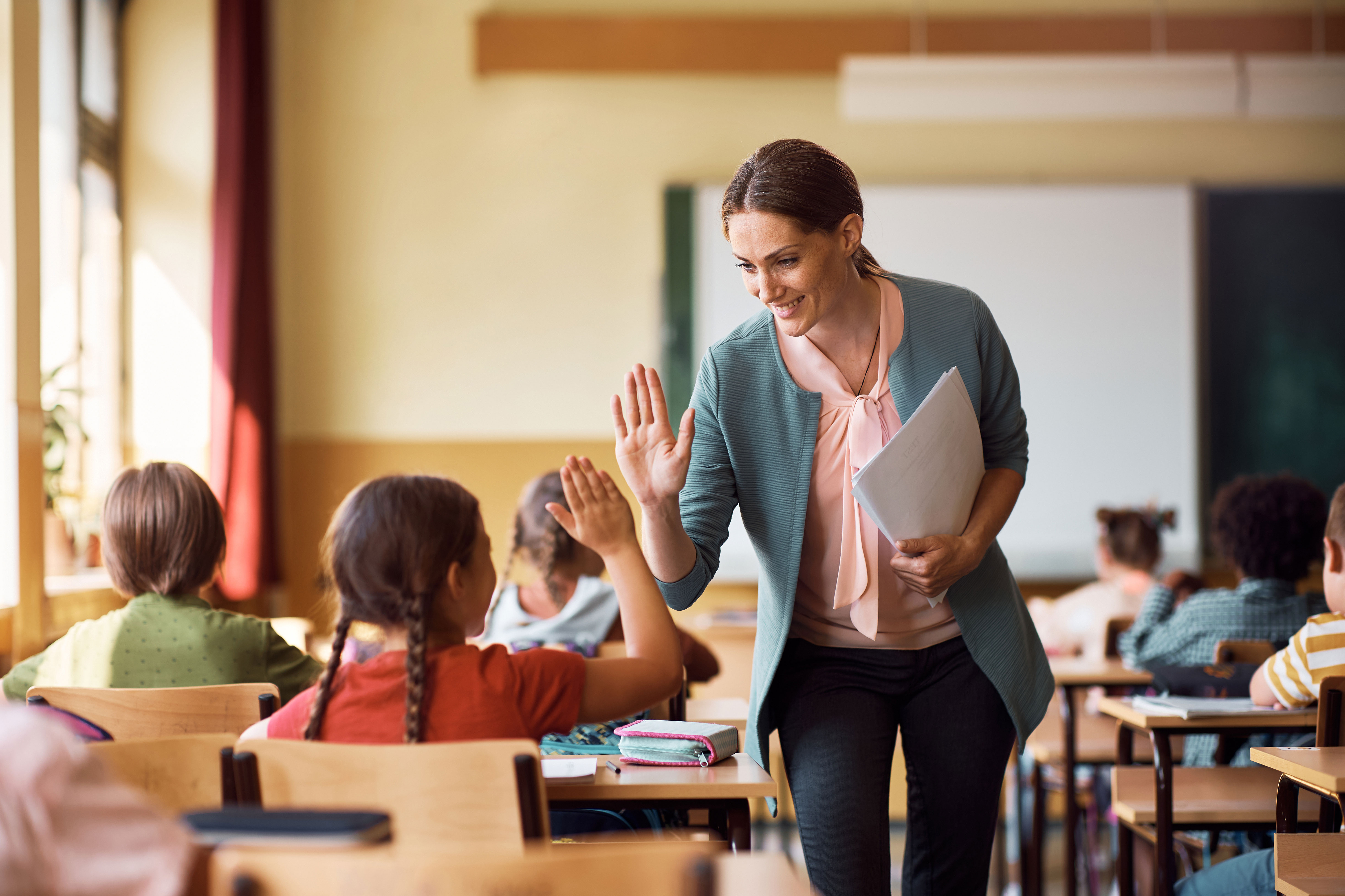 A teacher high-fiveing a student
