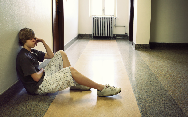 Student sitting on the floor by himself