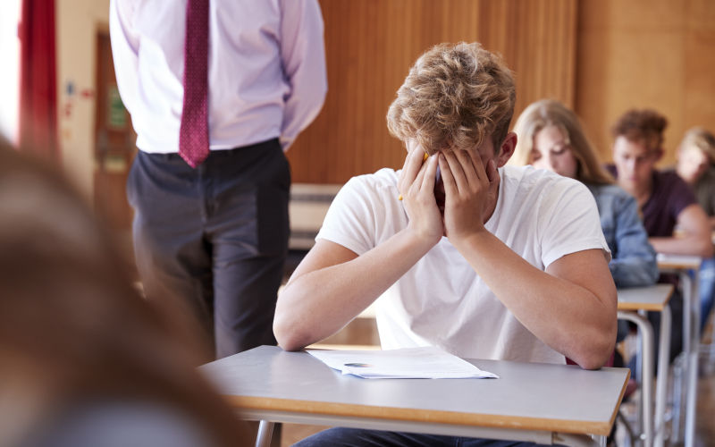 A High School students has hands over his face, crying