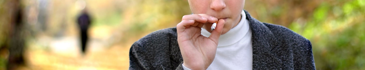 Male student smoking a cigarette outside