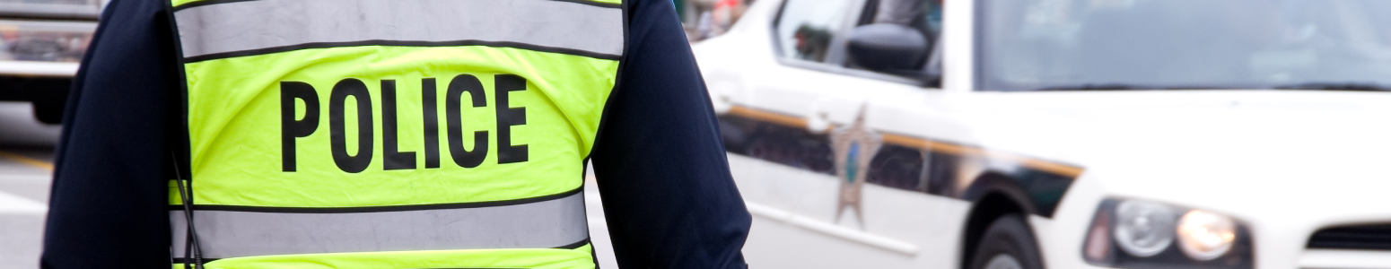 Police officer standing outside with back to the camera